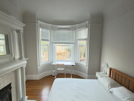 Unit 552: a private room with a fireplace and a bay window